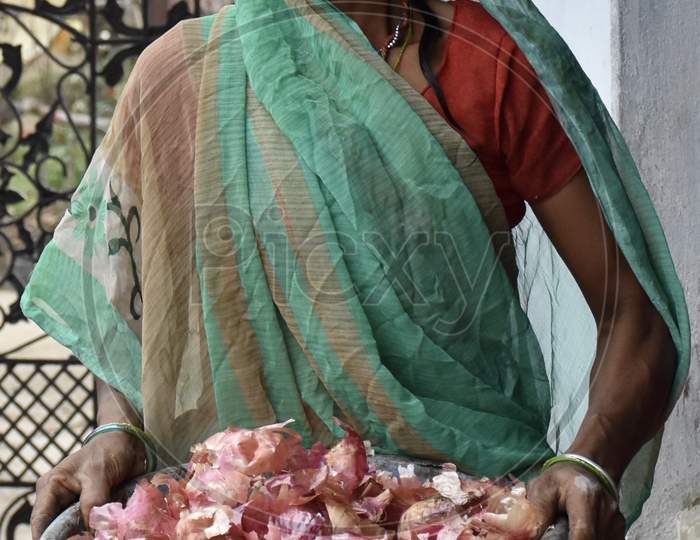 Indian Woman Holding A Tub Of Onion Peels