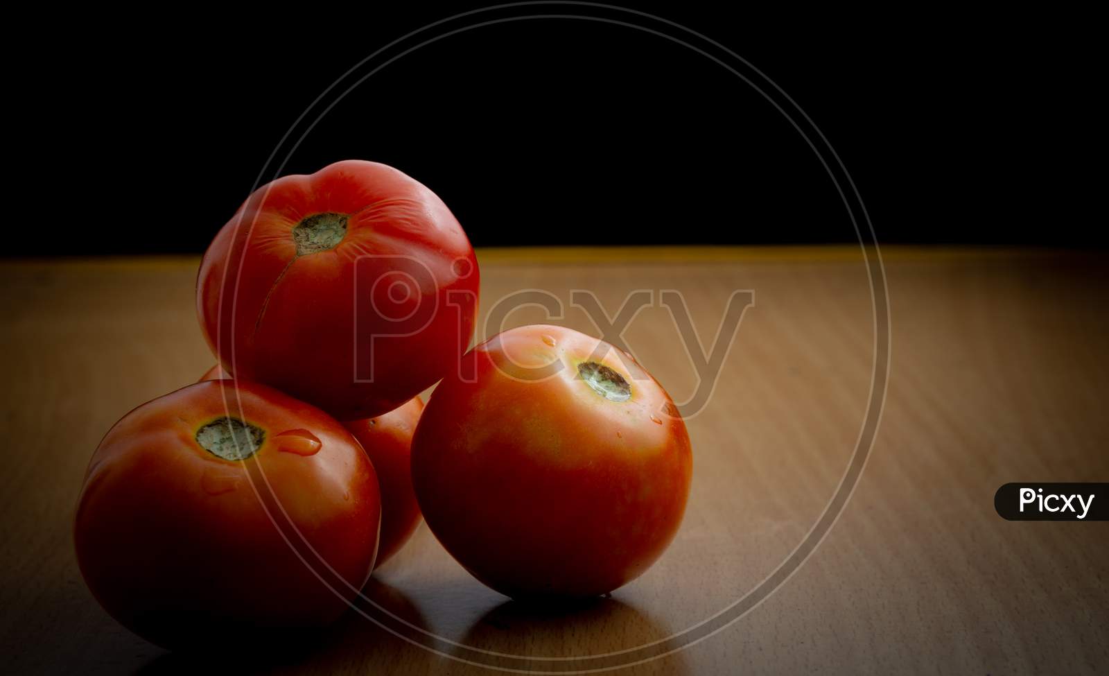 Juicy Tomatoes On A Wooden Table