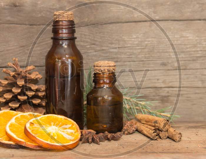 Bottle With Natural Orange, Pine And Cinnamon Oils. Aromatherapy And Natural Cosmetics Concept