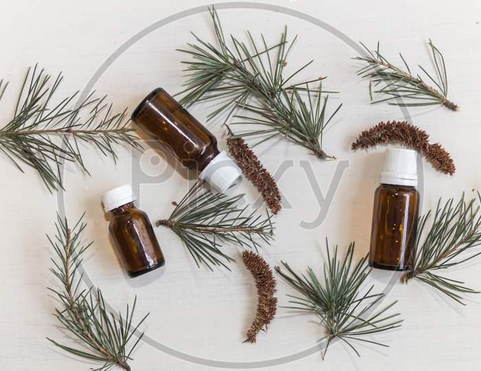 Top View Bottles With Cedar Oil. Aromatherapy And Natural Cosmetics Concept Background