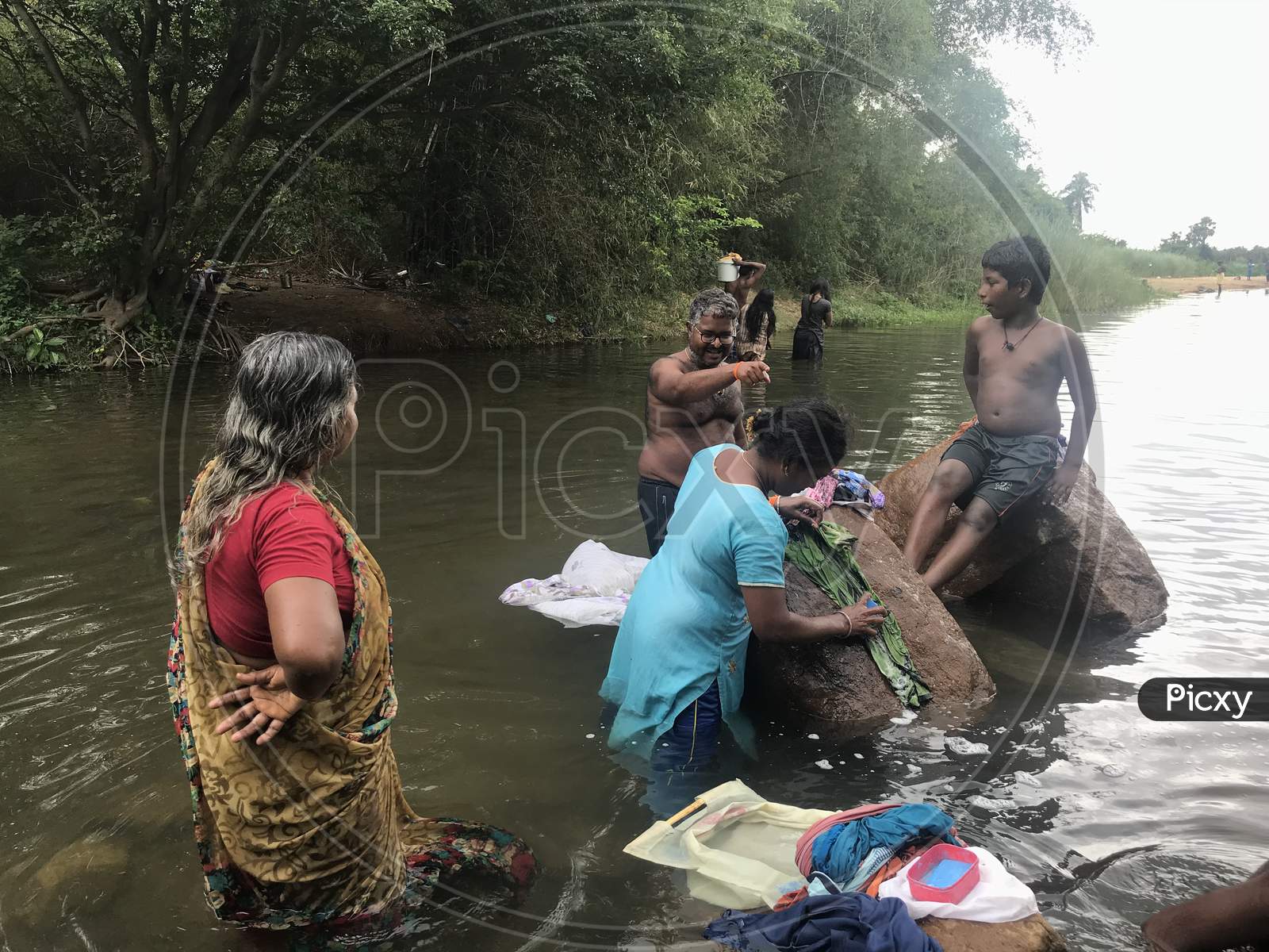 People From Family Altogether Enjoying The Natural Water Source In An Indian Forest And Enjoying Their Vacation Or Holiday