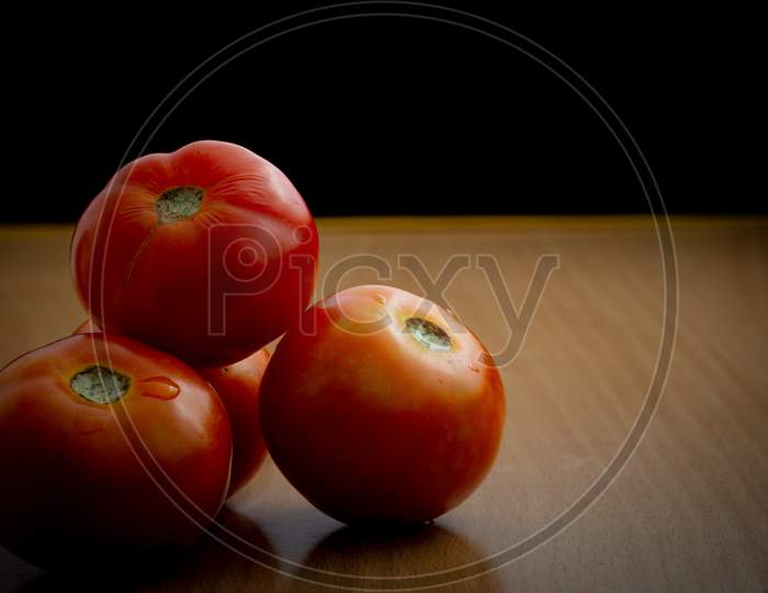 Juicy Tomatoes On A Wooden Table