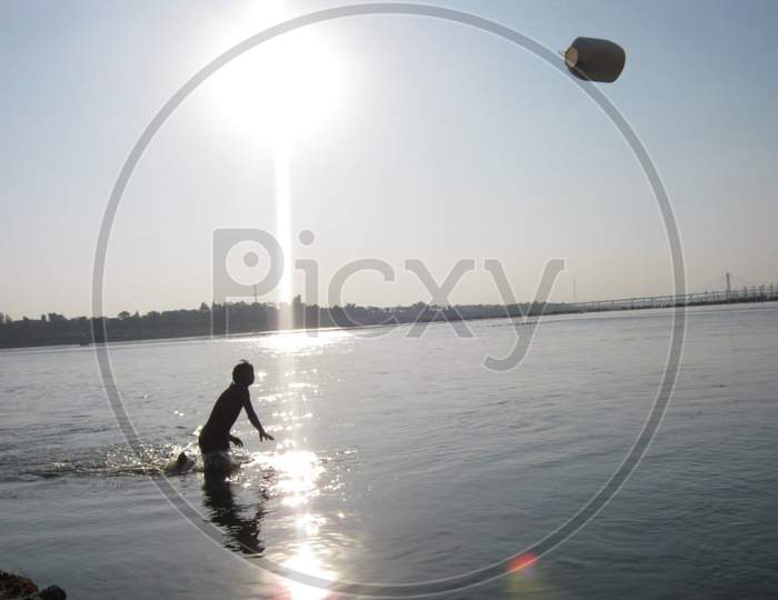 a boy play in the river ganga at sangam allahabad