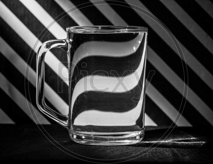 Abstract Image Of Distortions In A Glass Mug Placed In Front Of A Striped Background