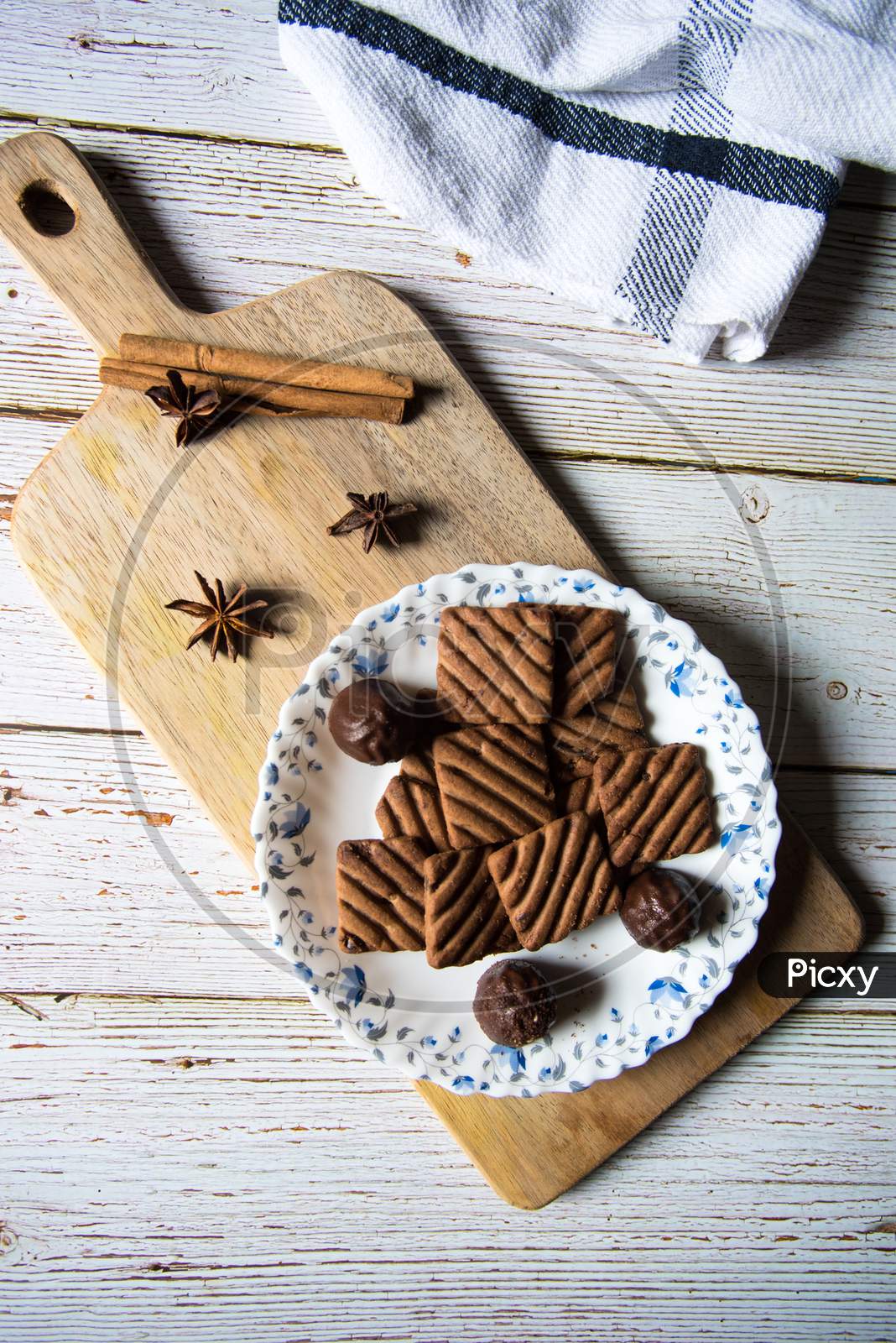 Tasty chocolate cookies and chocolates on a wooden platter