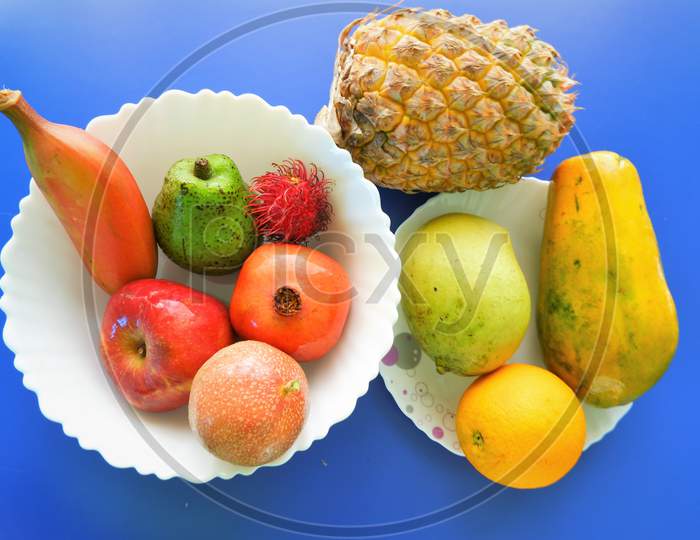 Healthy natural fruits on white plate ,top view,blue background