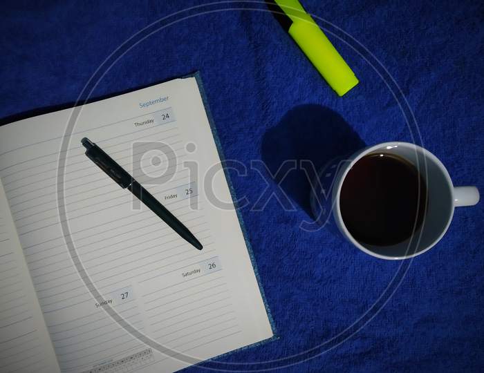 Coffee, diary, pen and highlighter