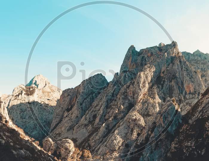 Super Panoramic View Of A Huge Rocky Mountains During A Sunset With Copy Space And A Clear Blue Sky