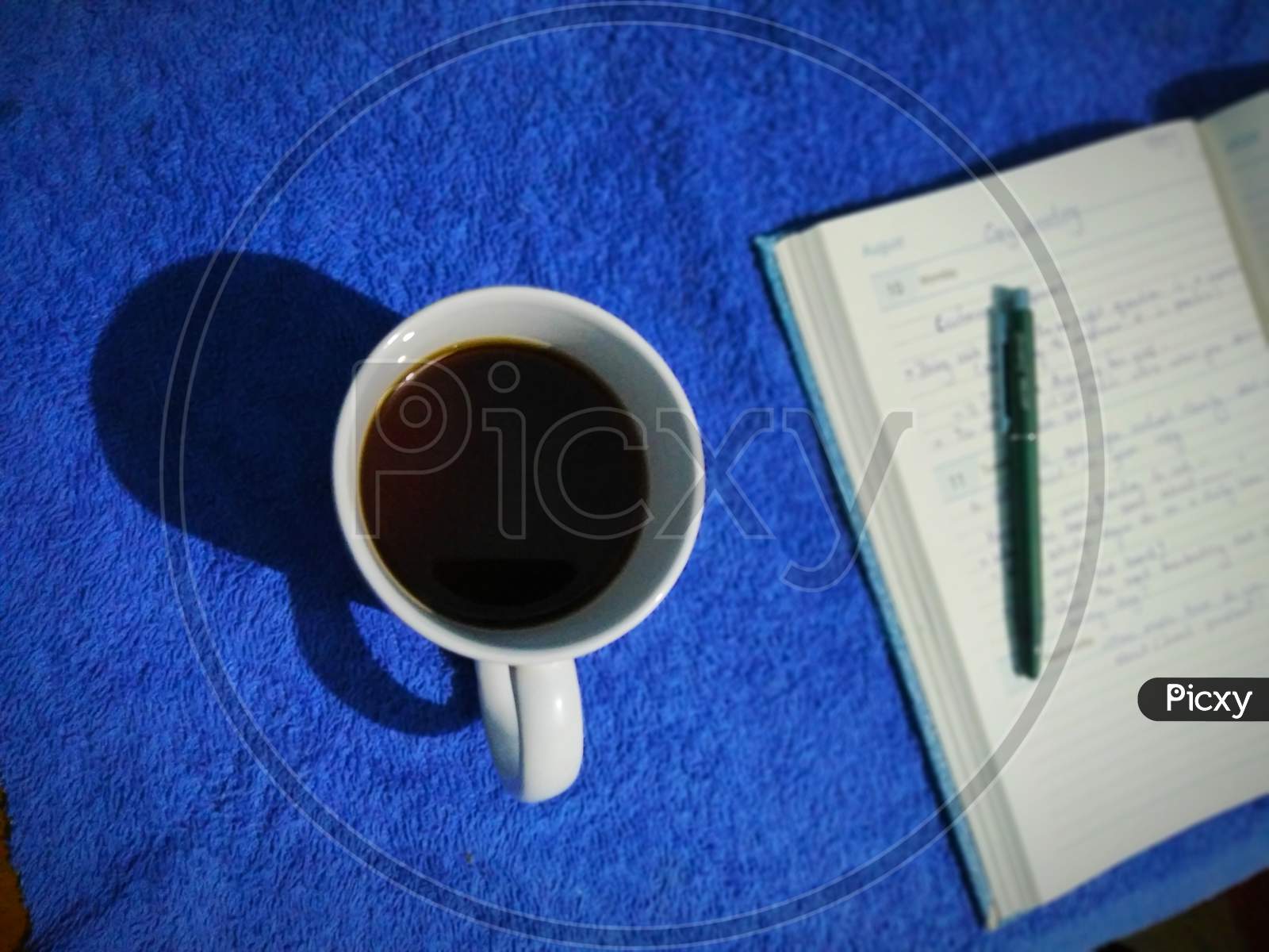 Coffee and notebook with pen