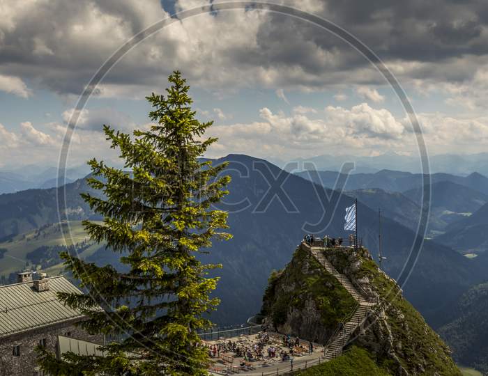 Wendelstein, Bavaria/Germany - July 17th 2020: A german photographer visiting the Wendelstein mountain via cable car, taking pictures of the mountain station restaurant at a cloudy day in summer.