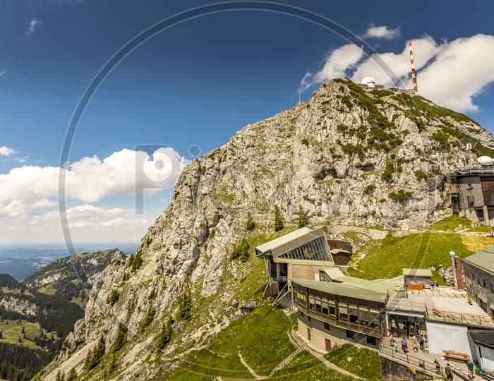 Wendelstein, Bavaria/Germany - July 17th 2020: A german photographer visiting the Wendelstein mountain via cable car, taking pictures of the mountain station restaurant at a cloudy day in summer.