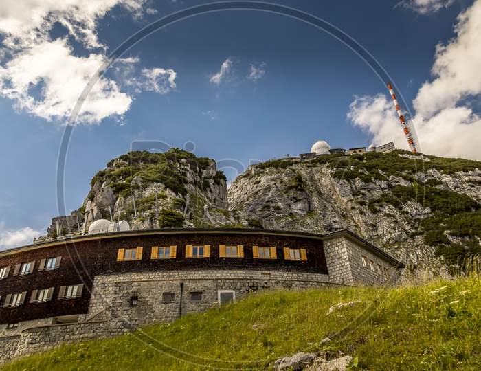 Wendelstein, Bavaria/Germany - July 17th 2020: A german photographer visiting the Wendelstein mountain via cable car, taking pictures of the mountain station at a cloudy day in summer.