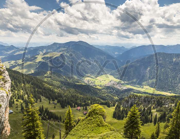 Hiking from the mountain station to the top of the mountain called Wendelstein in Bavaria, Germany at a cloudy day in summer. Beautiful panoramic view.