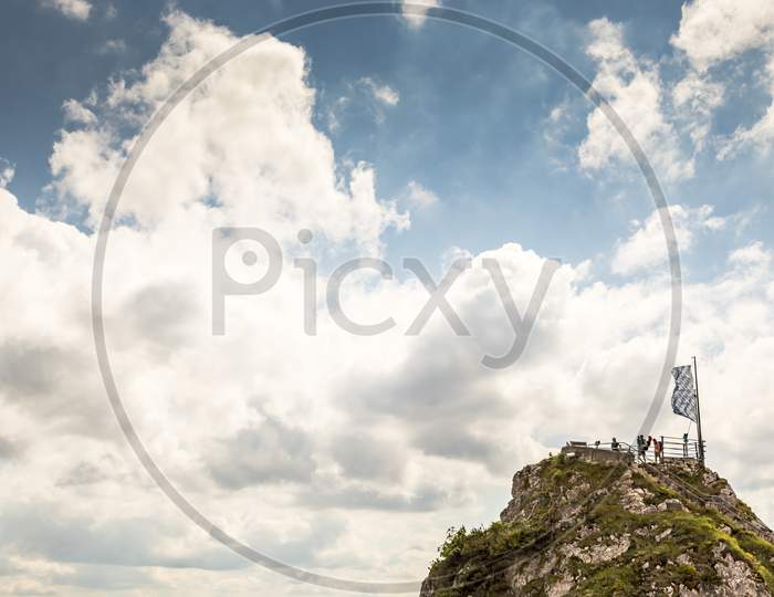 Wendelstein, Bavaria/Germany - July 17th 2020: A german photographer visiting the Wendelstein mountain via cable car, taking pics of the view point at the mountain station at a cloudy day in summer.