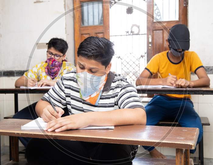 Indian Students Wearing Face Masks Maintaining Social Distancing At A Classroom As School Reopen During Covid19 Pandemic.