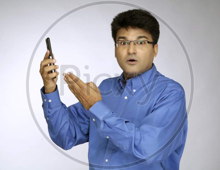 Man with Surprise Holding Mobile Phone