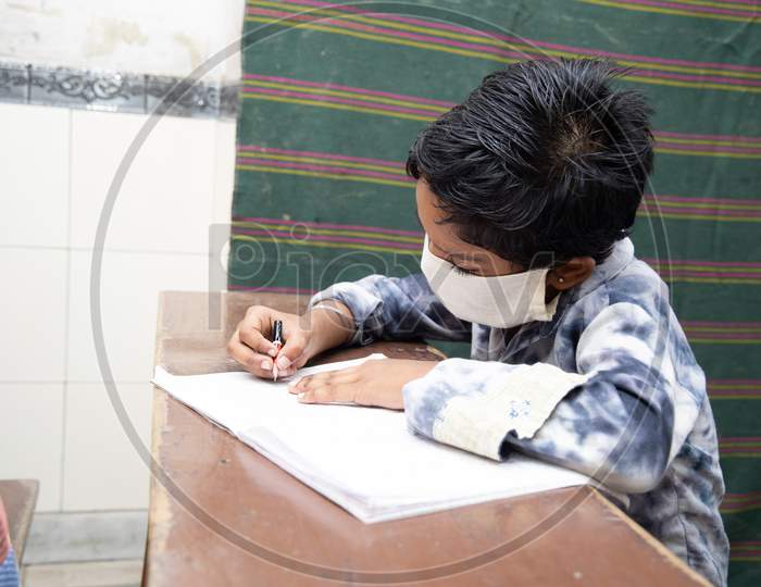 Indian student  Studying In Classroom Wearing Mask And Social Distancing, school reopen during covid19 pandemic