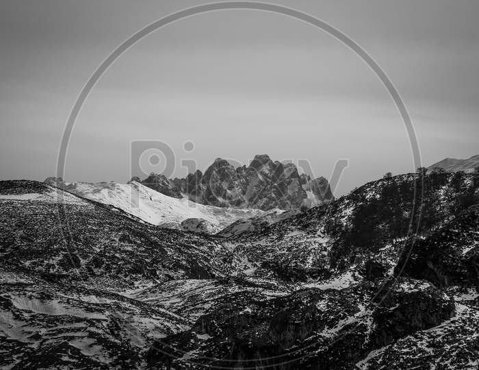 Massive And Risky Peak In The Mountain Range During Winter In A Dramatic Black And White
