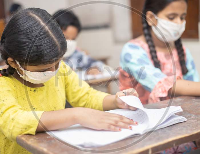 Indian Students Wearing Face Masks Sitting With Social Distancing At A Classroom As School Reopen During Covid19 Pandemic.