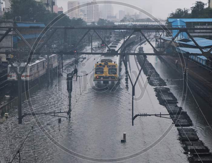 A train passes through waterlogged tracks after heavy rainfall in Mumbai, India, September 23, 2020.