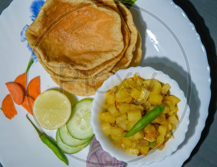 Indian Bengali Food Puri Or Luchi With Aloo Sabji (Potato Vegetable Dish). Indian Poori Is A Bread Deep Fried In Refined Oil. It Is A Traditional Bengali Breakfast Dish