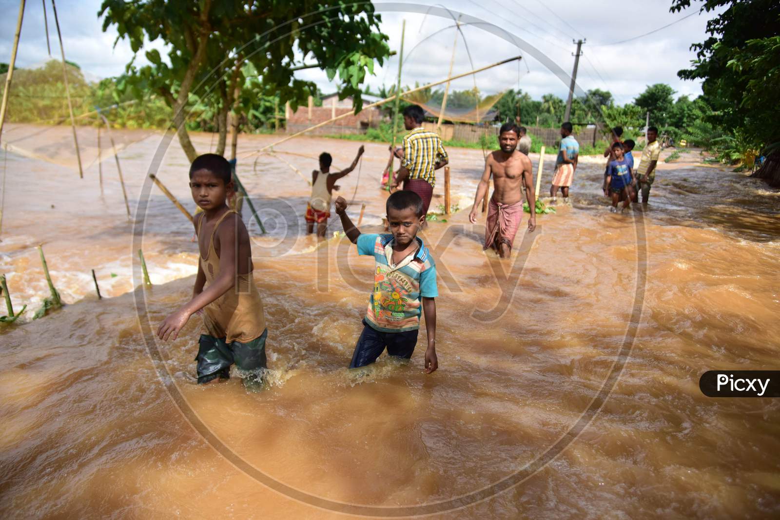 Children wade  through a flood water at Juripar village near Kampur  in Nagaon District of Assam on sep 25,2020.