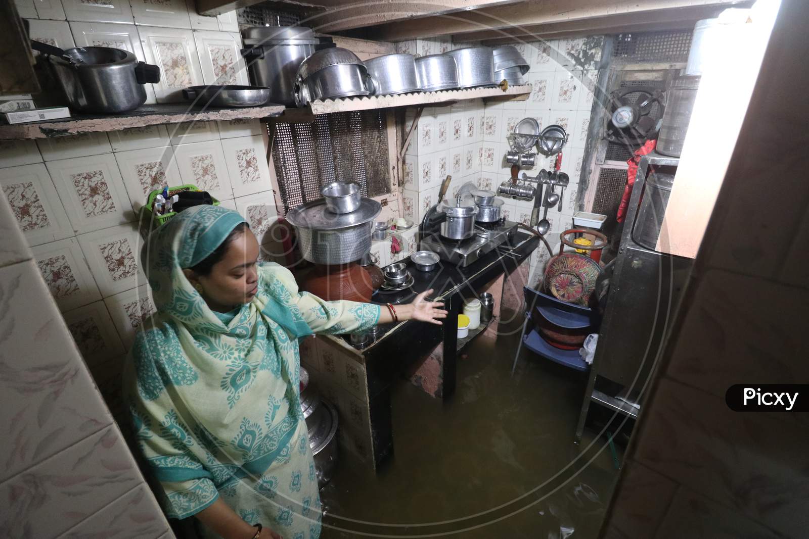 A woman show the kitchen inside her house that is waterlogged due heavy rains, in Mumbai, India on September 23, 2020.