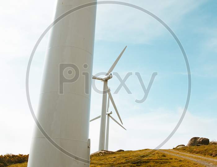 Line Of Windmills During A Sunny Day With A Colorful Tone And A Bright Sky With Copy Space