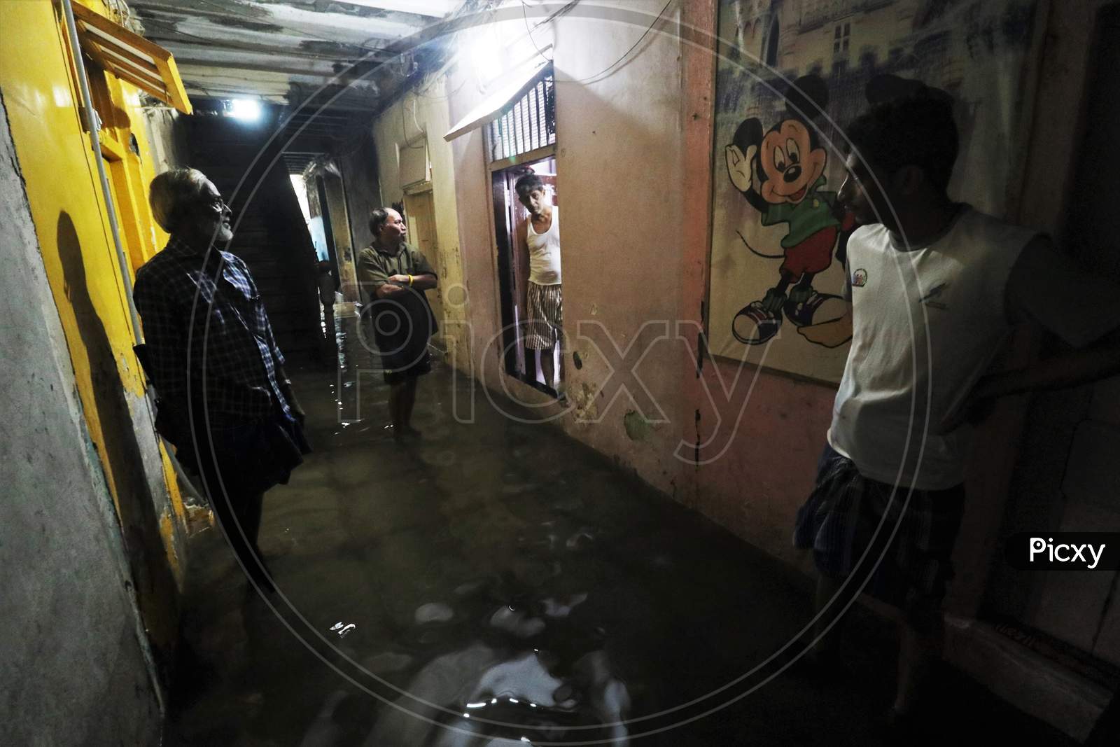 People stand outside their houses that are waterlogged due heavy rains, in Mumbai, India on September 23, 2020.