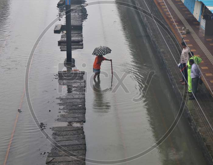 A man checks the depth of waterlogging on the tracks after heavy rainfall in Mumbai, India, September 23, 2020.