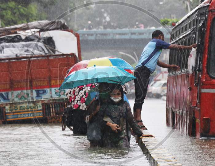 People wade through a waterlogged road after heavy rainfall in Mumbai, India, September 23, 2020.