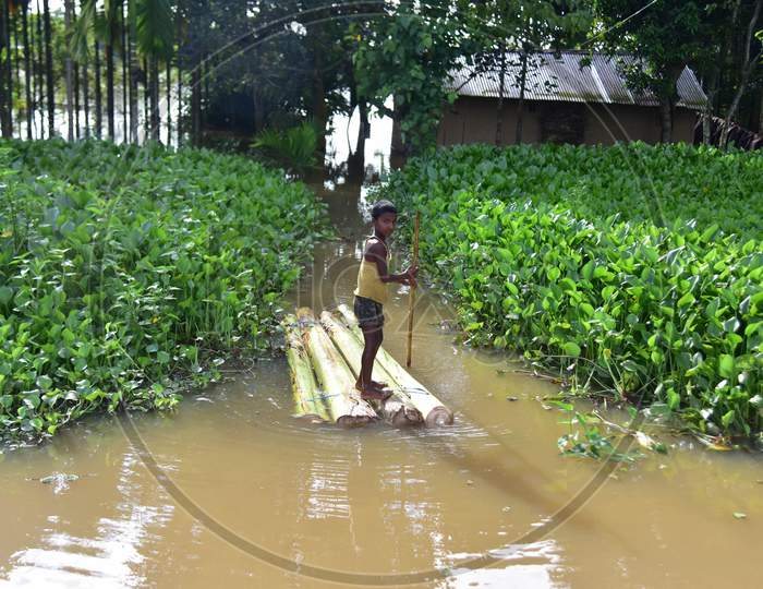 A boy rows a makeshift raft past submerged houses at a flood-affected village at Juripar village near Kampur  in Nagaon District of Assam on Sep 25,2020.