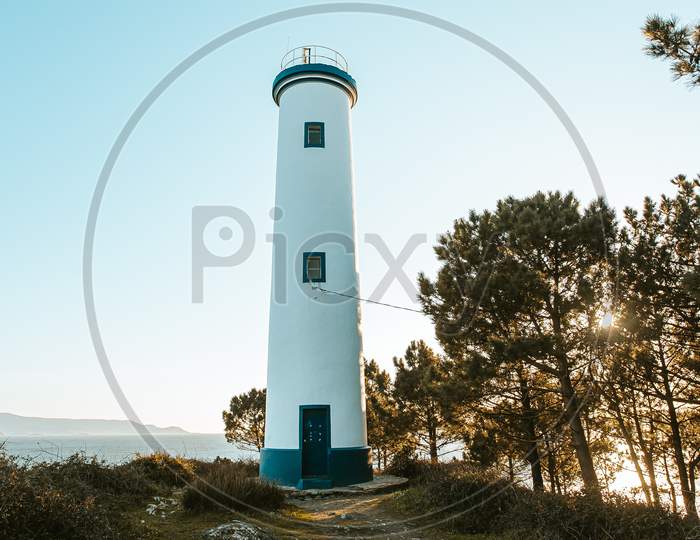 Beautiful White And Blue Lighthouse During A Sunny Bright Day In The Spanish Coast