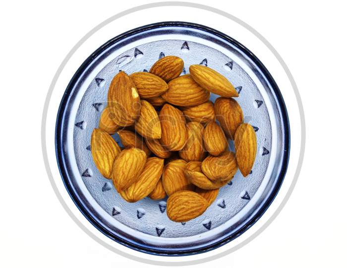 Fresh Almonds Nuts On A Blue Glass Bowl In A White Isolated Background.