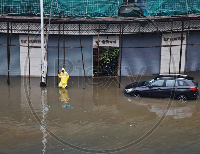 A policeman stands on a waterlogged road after heavy rainfall in Mumbai, India, September 23, 2020.