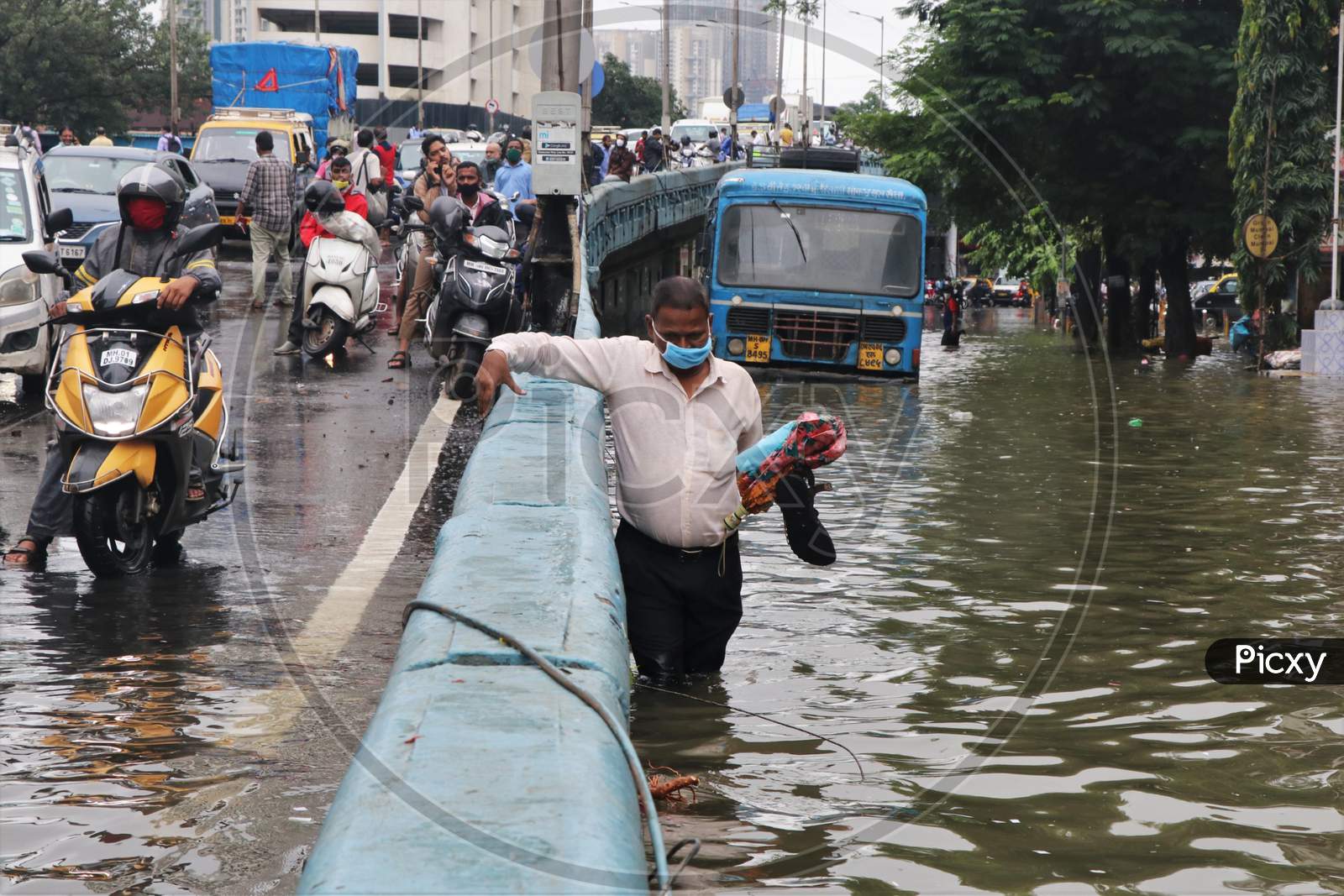 A man wades through a waterlogged road after heavy rainfall in Mumbai, India, September 23, 2020.