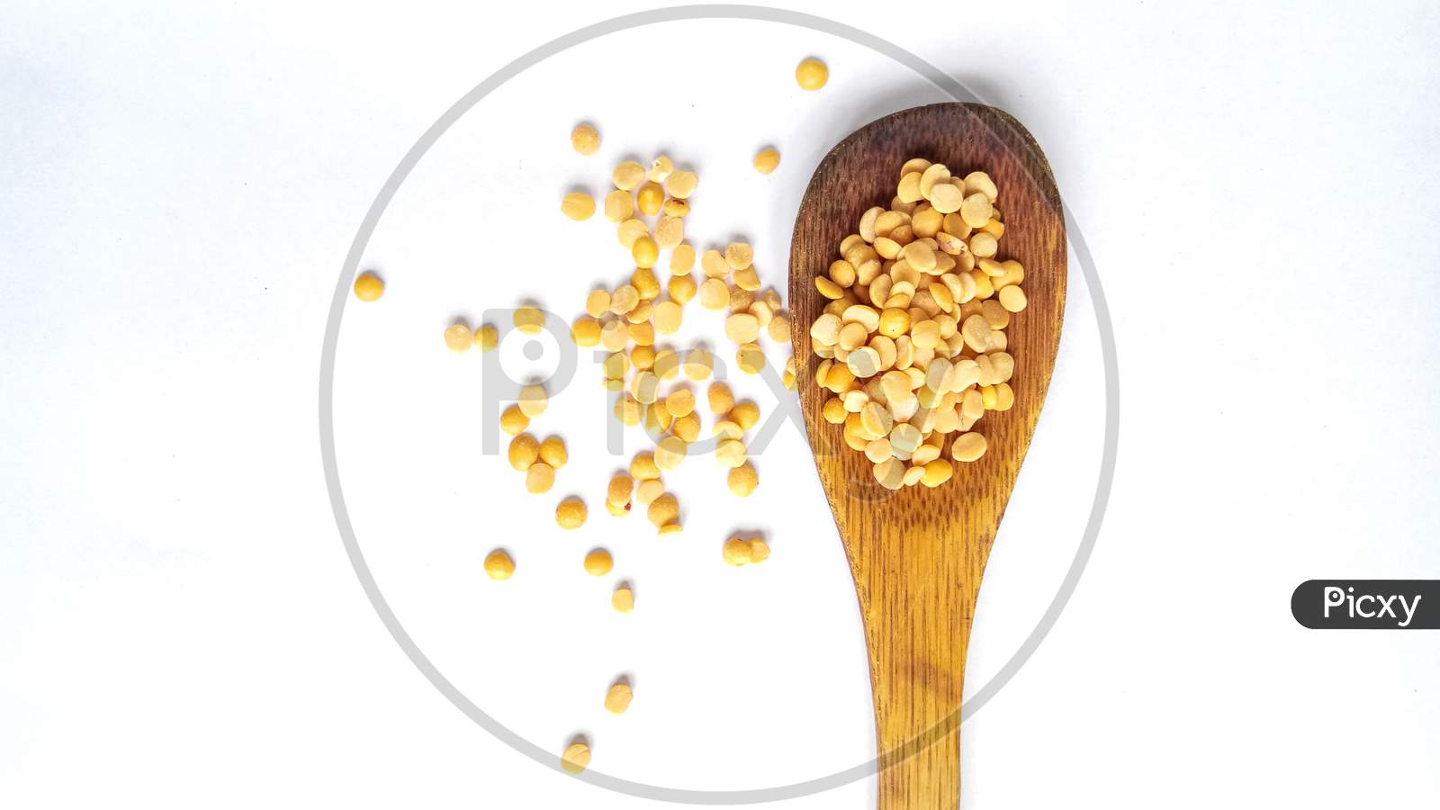 Yellow dal on wooden spoon isolated in white background