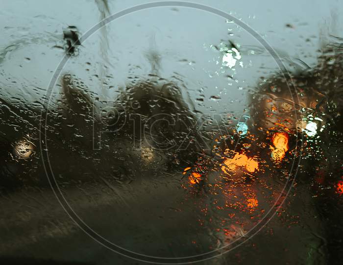 Rain Drops Over The Crystal Of The Car With A Super Texture And Colorful Reflections