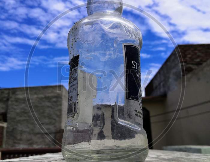 Glass bottle with cloudy sky