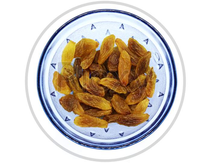 Fresh Organic Raisins On A Blue Glass Bowl.White Isolated Background.Dry Grapes.