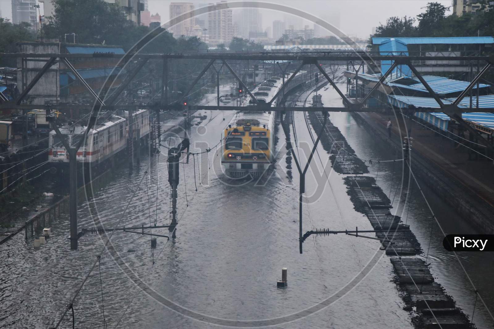 A train passes through waterlogged tracks after heavy rainfall in Mumbai, India, September 23, 2020.