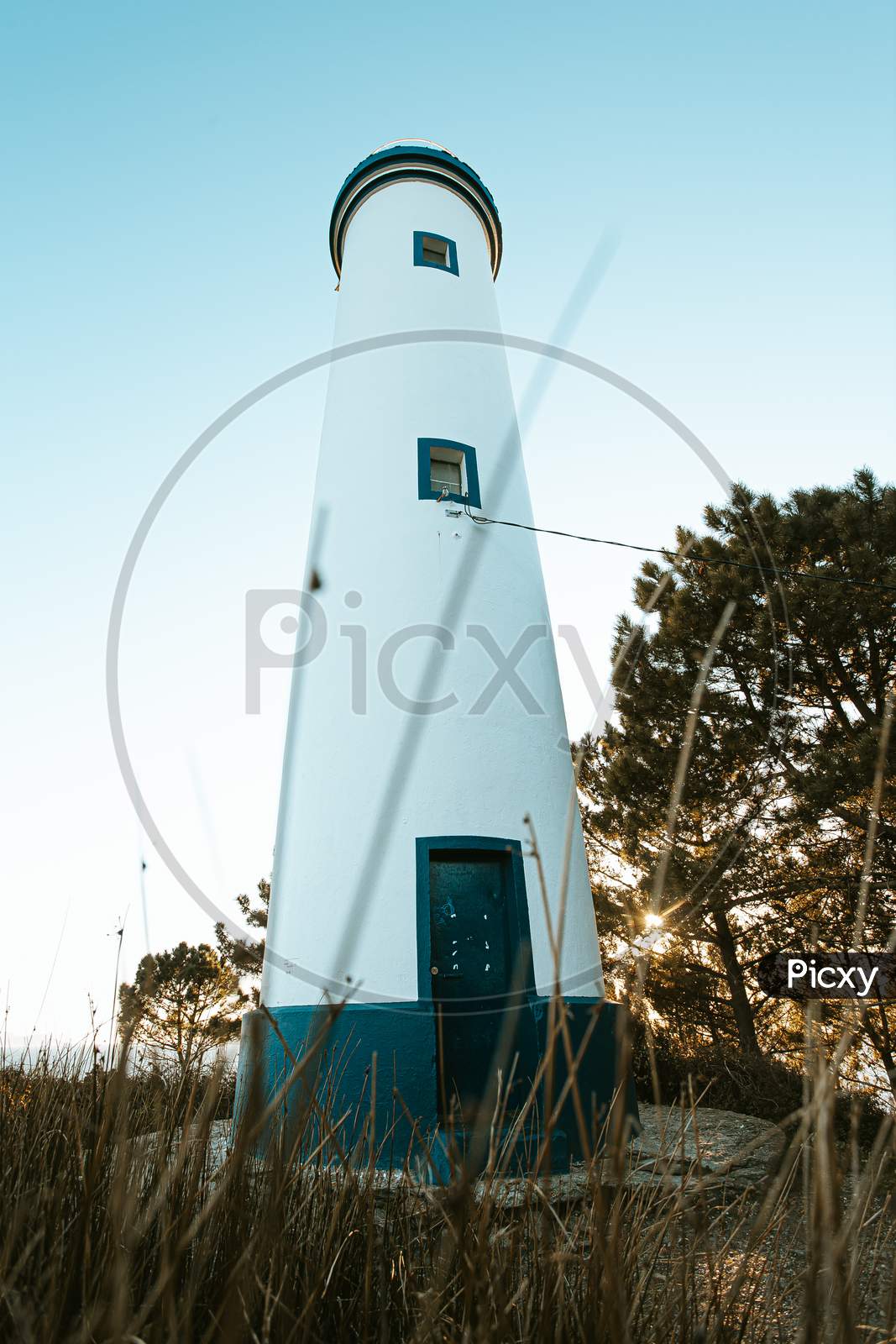 Beautiful White And Blue Lighthouse During A Sunny Bright Day In The Spanish Coast