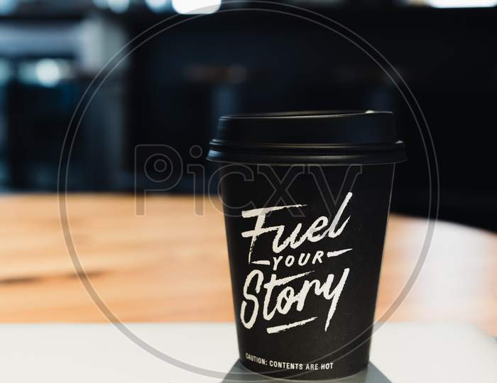 Black & White Cup of Coffee with Motivation Text " Fuel Your Story ".