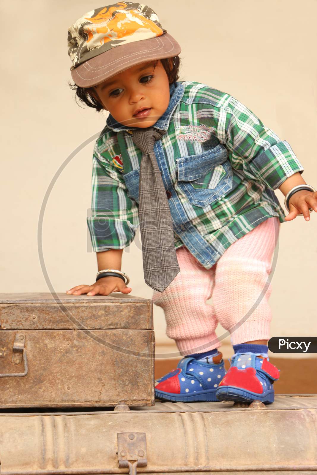 2 Year Old Beautiful Girl Wearing Cap Tie And Boy Dress, A 2 Year Old Girl Standing On Iron Box.