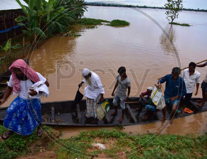 Flood-affected villagers are transported by a boat to safety at Kachua village in Nagaon district, in the northeastern state of Assam on Sept 26,2020.