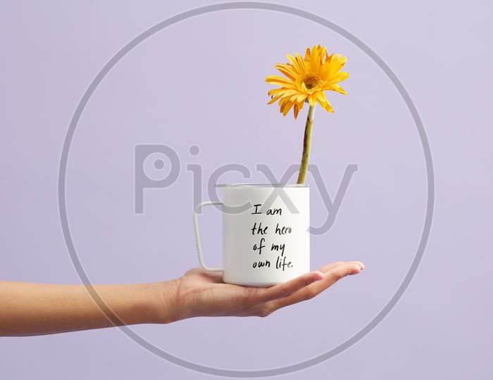 Yellow Petaled Flower In White Mug with a quote " I am the hero of own my life ".