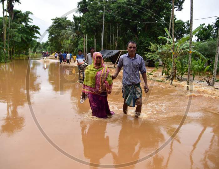 Villagers wade through water-logged road  to a safer place during heavy rain  at Kachua village  in Nagaon district, in the northeastern state of Assam on Sept 26,2020.