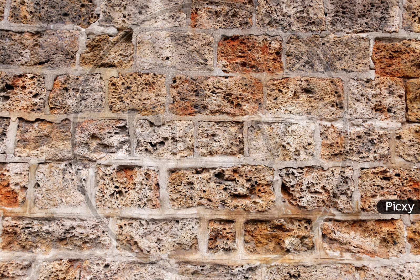 A Wall Formed By Spongy Textured Bricks Attached With Cement Solution