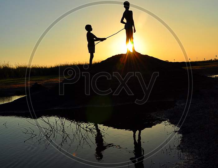 Silhouette of a  two boys near the lake while the sunsets