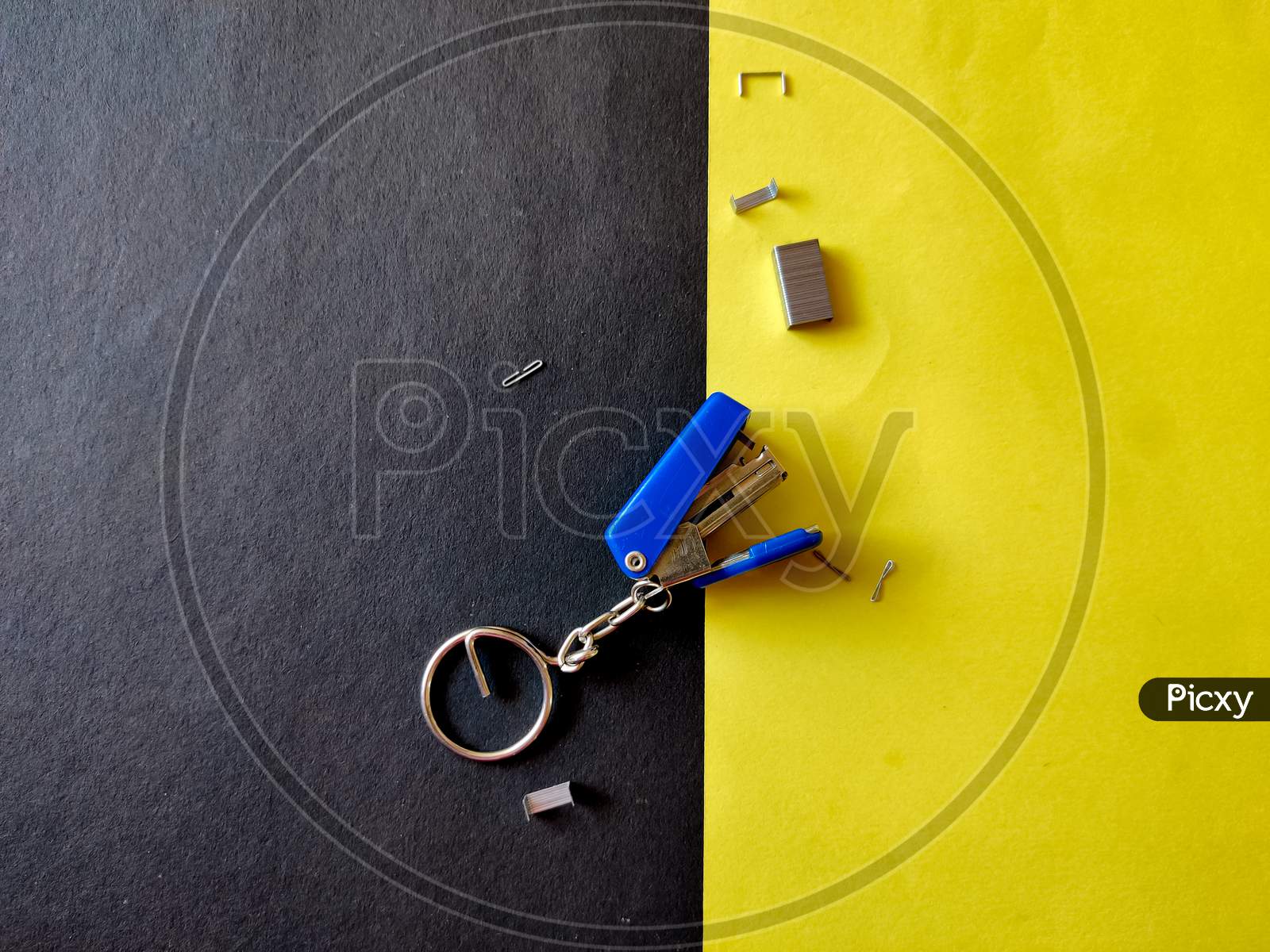 Small Blue Color Stapler Isolated On Yellow Background. Top View